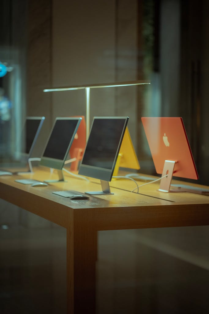 Vibrant desktop computers showcased on a wooden table in modern retail environment.